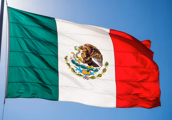 The modern flag of Mexico, prominently featuring the Aztec symbol of an eagle on a cactus devouring a snake.